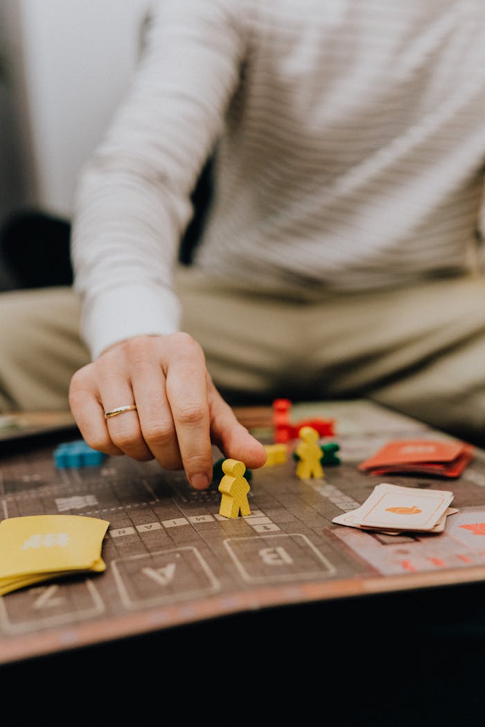 Crafting Captivating Headlines: Your awesome post title goes here Close-up of a hand placing a game piece on a board, adding strategy to the session.