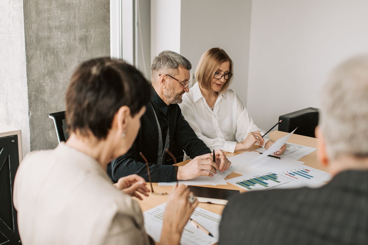 Team of professionals in office analyzing financial documents for business strategy.