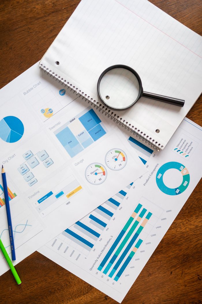 The Art of Drawing Readers In: Your attractive post title goes here A set of financial charts and graphs with a magnifying glass, perfect for business reports.